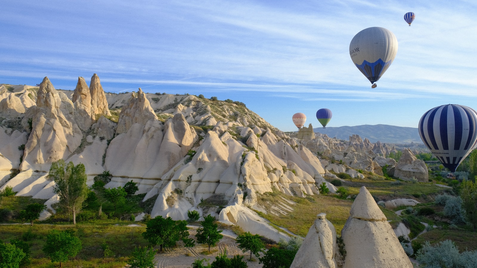 Hot air balloons rising over Cappadocia fairy chimneys at sunrise